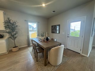 A cozy dining area with a wooden table, elegant decor, and bright natural light from the window and door.