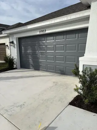 A modern gray garage door adorns this home in Central Park by Taylor Morrison, Port St. Lucie, FL.