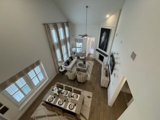 An elegant open-concept dining and living area with vaulted ceilings in Veramendi by Highland Homes (New Braunfels, TX).