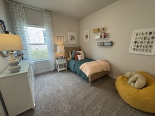 A cozy bedroom with a plush bed, soft lighting, and a sunny reading nook, perfect for rest and relaxation.