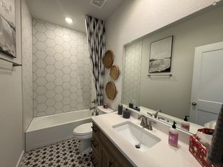 Model Home A chic bathroom with hexagonal tiles, a sleek vanity, and stylish decor elements.