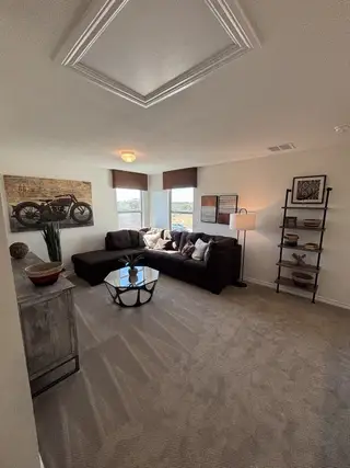 A cozy living area with a plush sectional, modern decor, and ample natural light.