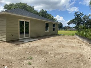 A charming beige home with sliding glass doors and a spacious backyard in Whistler Woods by Lennar (Jacksonville, FL).