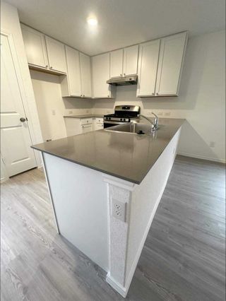 A stylish kitchen with white cabinets, stainless steel appliances, and a spacious island with a dark quartz countertop.