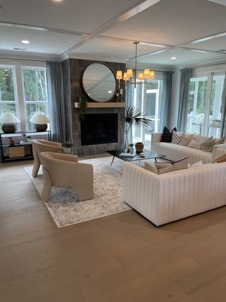 Elegant living area with plush seating, a modern fireplace, and large windows offering serene views.