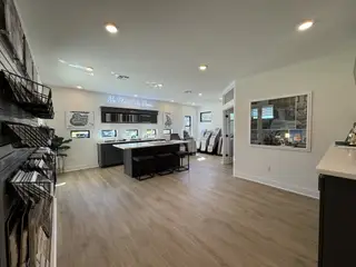 A modern sales office with sleek displays, cozy seating, and elegant wood flooring.