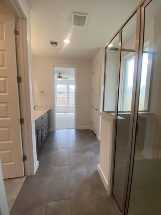 Model Home A modern bathroom with sleek glass shower, dark vanity, and contemporary tile flooring.