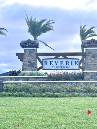 Street view Scenic entrance with stone columns and lush landscaping at Reverie at Silverleaf by Dream Finders Homes (St. Augustine, FL).