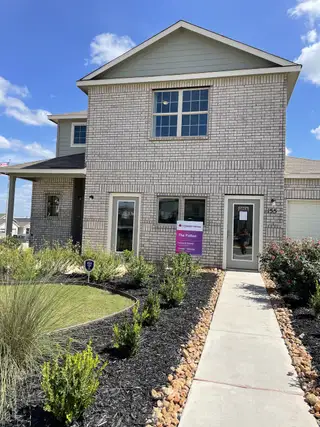 A modern brick home with a tidy yard in Hunters Ranch by Legend Homes (San Antonio, TX).