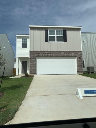 Modern two-story home with a brick facade and spacious garage in Sonterra by Starlight Homes, Jarrell, TX.