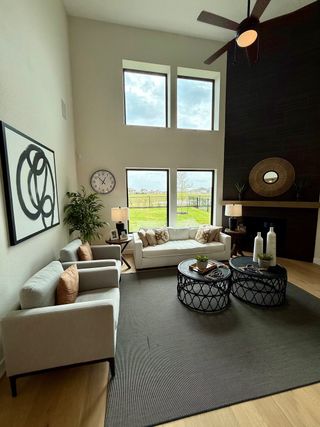 A modern living room with plush seating, tall windows, a sleek fireplace, and stylish decor accents.