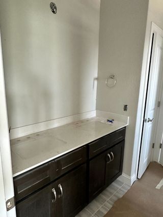 A sleek bathroom featuring dark wood cabinetry, a clean white countertop, and elegant hardware for a modern touch.