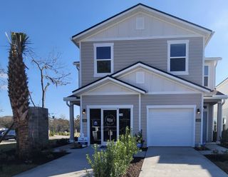 A charming two-story home with a tidy lawn and palm tree in Irongate Villas by D.R. Horton (Jacksonville, FL).