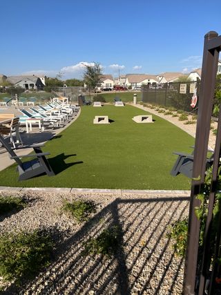 Charming outdoor area with lawn games and seating in Los Cielos at Rancho Mercado by Taylor Morrison (Surprise, AZ).