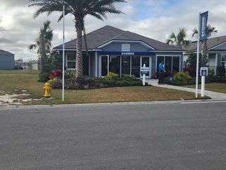 A stylish sales center with a modern design, palm trees, and inviting curb appeal at The Arbors by D.R. Horton (Jacksonville, FL) 
