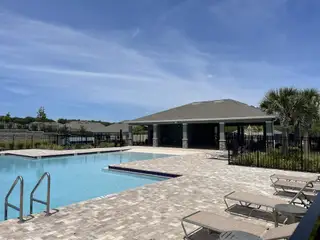 Community Amenities A resort-style pool with a spacious deck, lounge chairs, and a shaded pavilion for relaxation in Timberwalk by D.R. Horton (Mount Dora, FL).