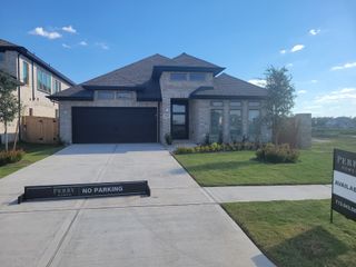 Street view A modern brick home with a spacious driveway in Fulbrook on Fulshear Creek 60' by Perry Homes (Fulshear, TX).