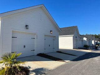 Charming white garages line the street in Nexton - Midtown by Saussy Burbank (Summerville, SC).