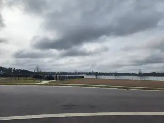 Expansive open space with a fenced perimeter and cloudy sky in Westport Landing by LGI Homes (Jacksonville, FL).