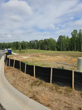 A scenic, undeveloped lot surrounded by lush trees in Wildwood Place by Traton Homes (Powder Springs, GA).