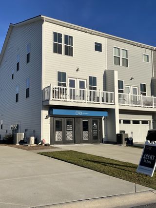 A contemporary townhouse with large windows and sleek design at Recess Pointe Townhomes by DRB Homes (Moncks Corner, SC).