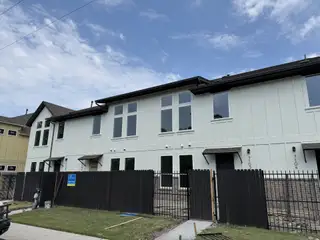 Street view Contemporary white townhomes with sleek designs in Koenig Townhomes by Milestone Community Builders (Austin, TX).