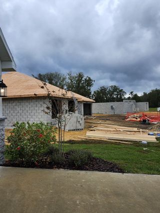 A street view of the Cadence Crossing community by Adams Homes, with fresh landscaping and homes in various stages of completion (Auburndale, FL).