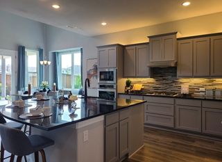 Model Home A modern kitchen featuring sleek cabinetry, a spacious island, and elegant lighting, perfect for stylish entertaining.