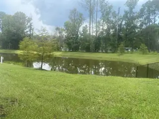 Community Amenities A serene lakeside view with lush greenery in Old Kings Trail by D.R. Horton (Jacksonville, FL).