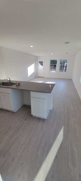 An open-concept living area with elegant wood floors, a sleek kitchen island, and ample natural light.