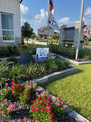 Street view A charming landscaped entrance in River Ranch by Long Lake Ltd. featuring vibrant flowers and modern signage (Dayton, TX).