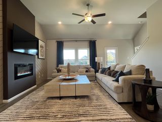 A cozy living room featuring a modern fireplace, plush sofas, and a stylish coffee table with elegant decor.