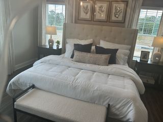 A cozy bedroom featuring a plush tufted headboard, elegant decor, and soft lighting for a serene ambiance.