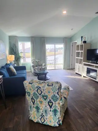 Model Home A vibrant living space with coastal-inspired decor, large windows, and a serene view of the water.