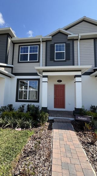 Model Home A stunning model home exterior with stone accents, lush landscaping, and inviting curb appeal in Emerson Pointe by M/I Homes (Apopka, FL).