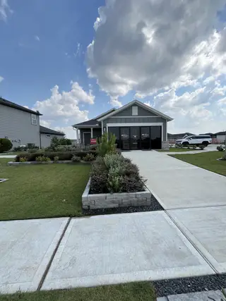 A modern home with a landscaped yard and spacious driveway in Redbud 45s by Taylor Morrison (Hockley, TX).