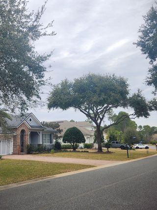 A charming brick and stucco home with a well-manicured lawn in Amelia National by ICI Homes (Fernandina Beach, FL).