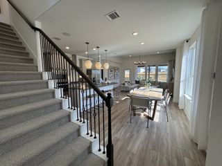 A beautifully designed open-concept living space with a grand staircase and modern accents.