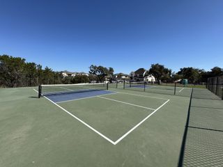 Community Amenities A modern tennis court set in the scenic community of Parkside on the River by Coventry Homes in Georgetown, TX.