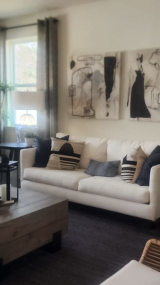 A contemporary living room with abstract artwork, natural elements, and an inviting neutral color palette.