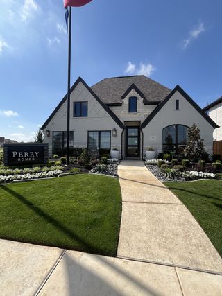 Street view A charming brick home with modern design and lush landscaping in Sweetgrass 50' by Perry Homes (Haslet, TX).
