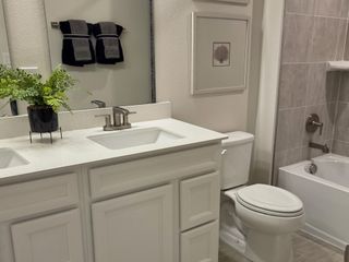 A modern bathroom featuring a dual-sink vanity, sleek fixtures, and elegant tiling.