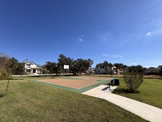Community Amenities A charming home near a basketball court and lush greenery in Highland Village by Coventry Homes (Georgetown, TX).