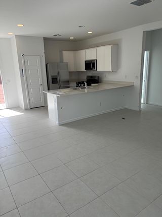 A modern kitchen with sleek white cabinets, spacious counters, and ample natural light.