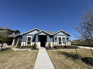 Street view A charming blue home with a landscaped yard in Easton Park by Pacesetter Homes (Austin, TX).