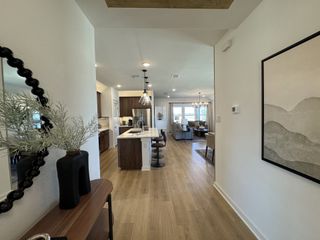 A modern open-concept living area with sleek wood flooring, contemporary decor, and a spacious kitchen island.