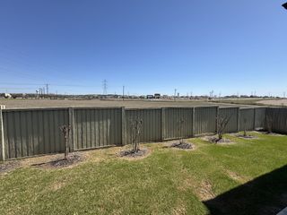 A serene backyard view with a green fenced yard and expansive fields in Foxbrook by Scott Felder Homes (Cibolo, TX).
