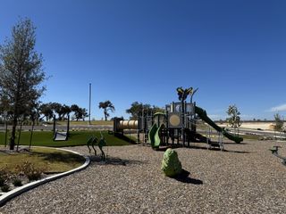 A vibrant playground with modern equipment in Nolina 60' by Perry Homes, Georgetown, TX. Perfect for family fun.
