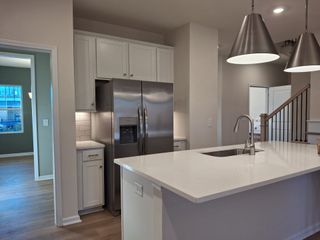Model Home A modern kitchen featuring sleek stainless steel appliances, a white island, and pendant lighting for a stylish finish.