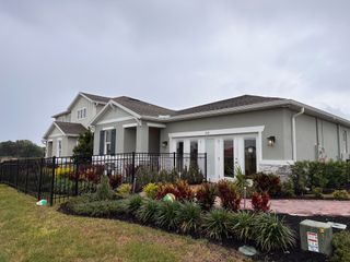 A charming gray home with elegant features and lush landscaping in Seasons at Heritage Square by Richmond American Homes (Haines City, FL).